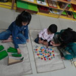 Two children working together on a floor activity