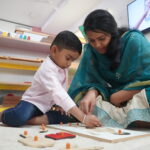 Teacher helping a boy with a hands-on activity