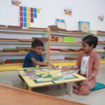 Girl working near a classroom shelf with decorations on the wall behind