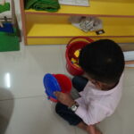 Child absorbed in an activity beside a colourful shelf